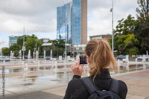 A tourist takes pictures with their mobile at Fountain Square in Geneva