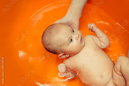 Fototapeta bathing baby in water in the mother's arms the joy of laughter