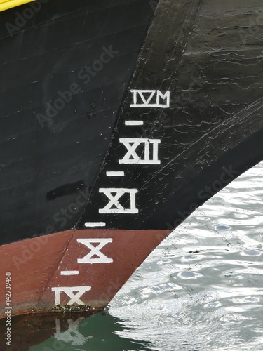 Close up of vintage wooden sailing ship bow with plimsoll line mark. Vertical view.