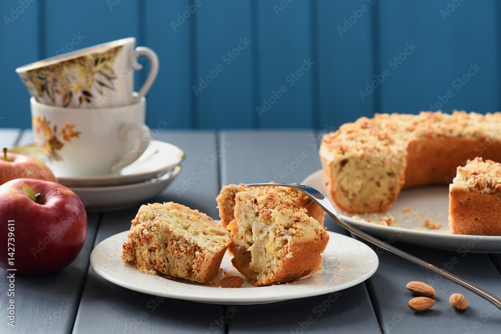Tea table with homemade almond cake, cups and apples Tea table with homemade almond cake, cups and apples