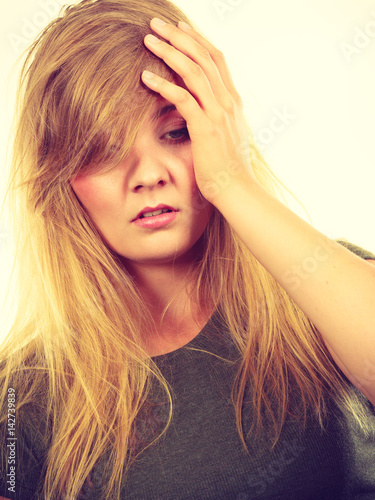 Ashamed embarrassed blonde woman with hand on face