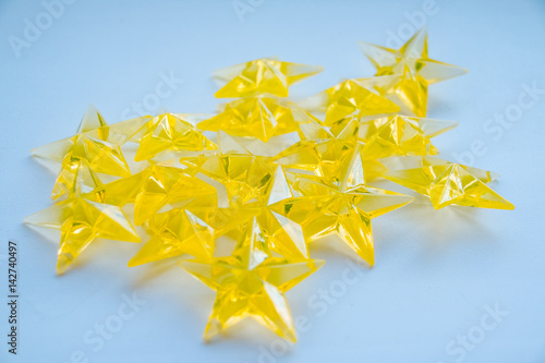 yellow plastic stars on blue background. This stas are part of a garland. Party glitter, isolated on blue photo