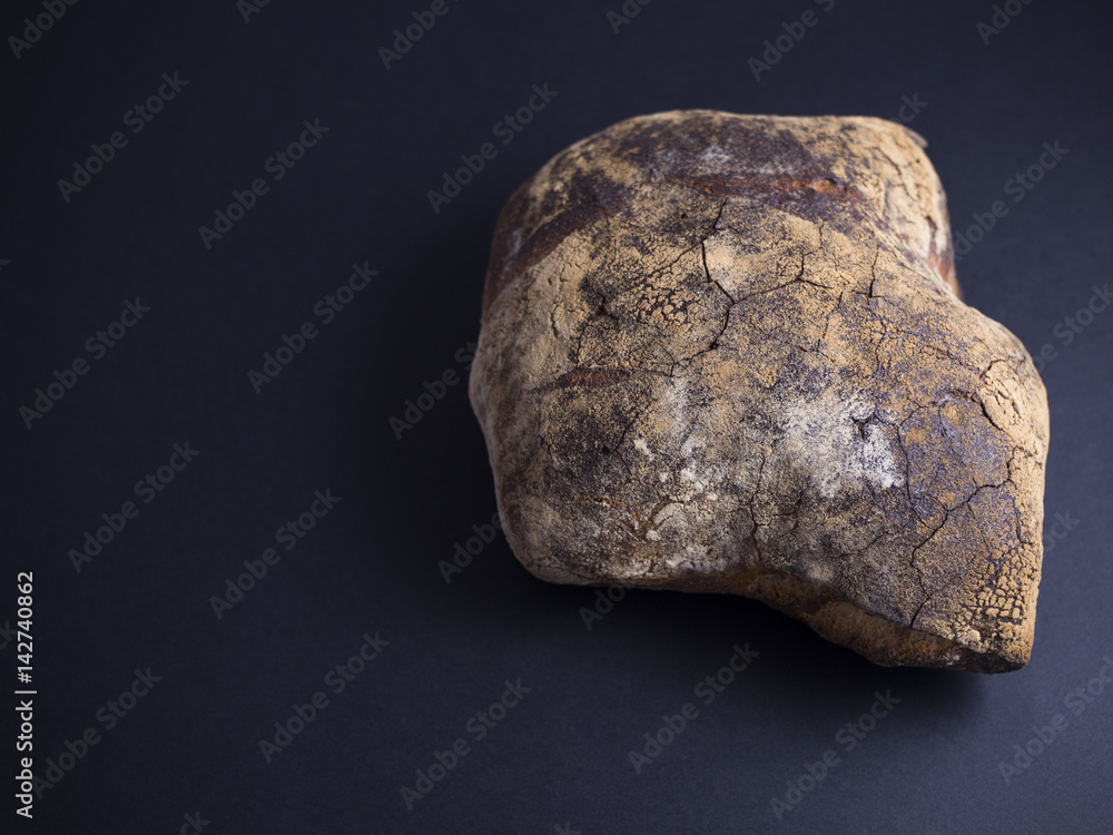 Rustic bread with brown crust made in wood fire oven isolated on black background Rustic bread with brown crust made in wood fire oven isolated on black background