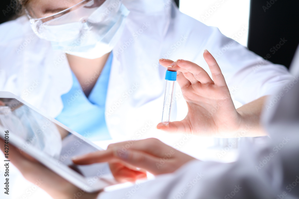 Scientific research team with clear solution in laboratory, close up Scientific research team with clear solution in laboratory, close up