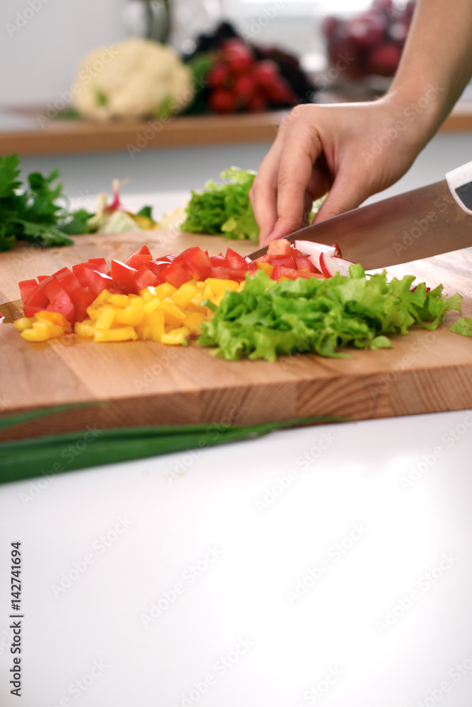 Close up of woman's hands cooking in the kitchen. Housewife slicing fresh salad. Vegetarian and healthily cooking concept Close up of woman's hands cooking in the kitchen. Housewife slicing fresh salad. Vegetarian and healthily cooking concept