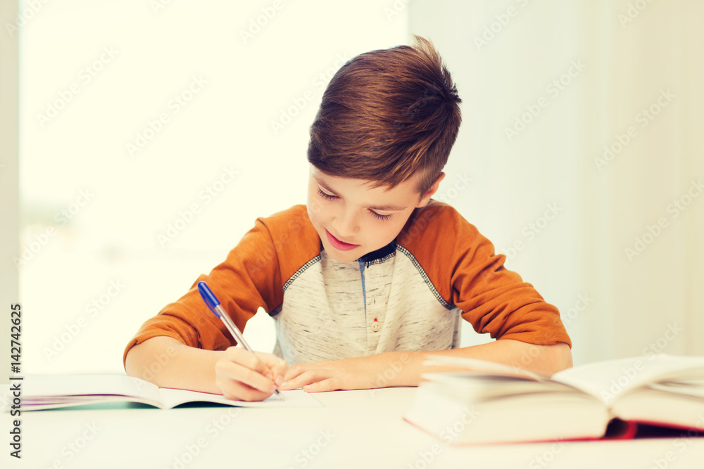 smiling student boy writing to notebook at home smiling student boy writing to notebook at home