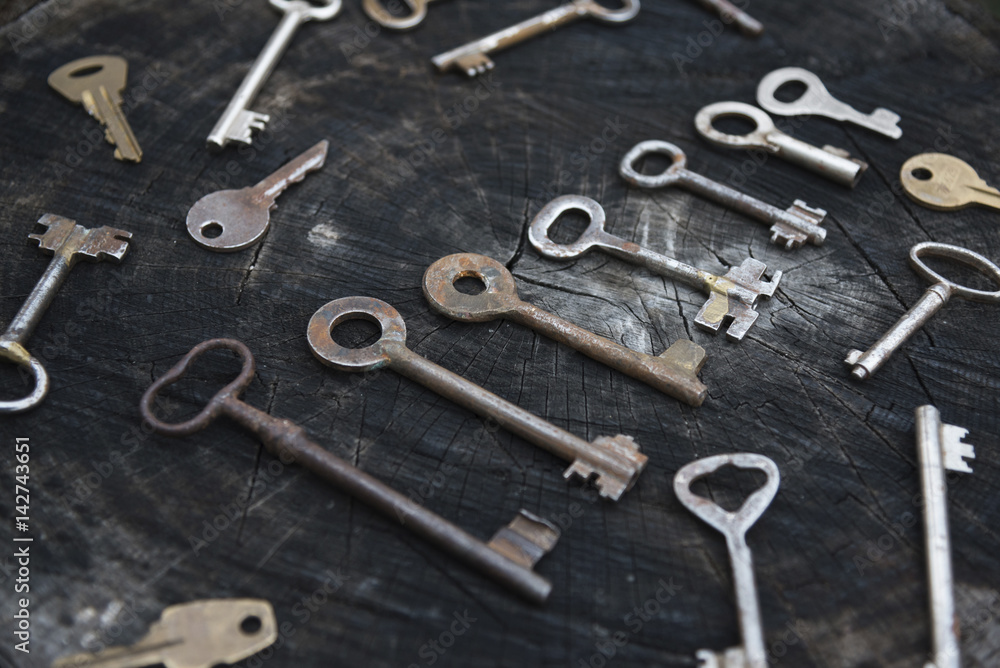 Scattered collection of old keys on a wooden surface Scattered collection of old keys on a wooden surface