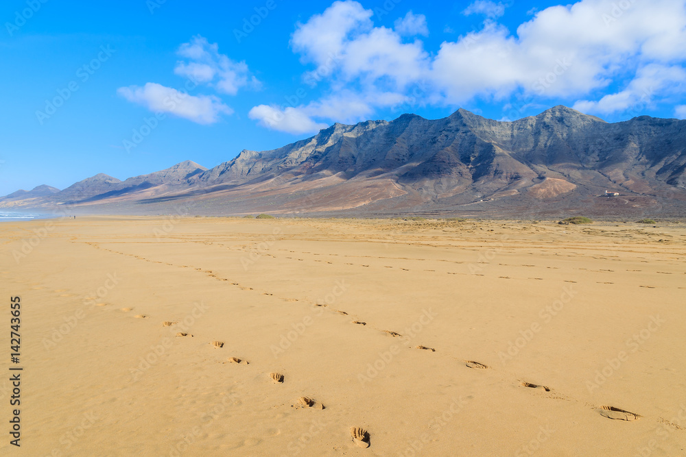 Footprints in sand on Cofete beach in secluded part of Fuerteventura, Canary Islands, Spain Footprints in sand on Cofete beach in secluded part of Fuerteventura, Canary Islands, Spain