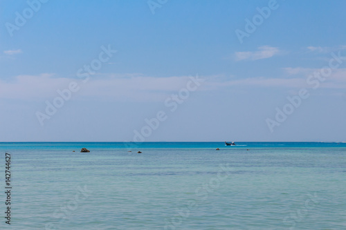 Long Tail boat in Thailand cruising on cyan blue water, panoramic