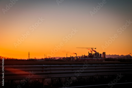 sun goes down behind an industry © zakaz86