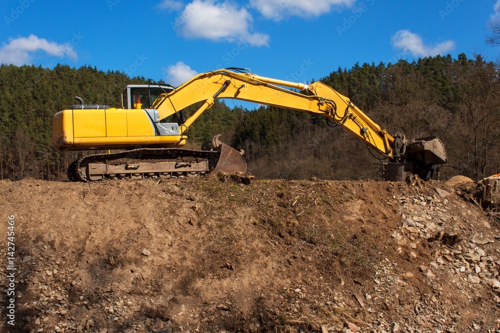 Excavator on the work to strengthen the shoreline of the river. Excavator on the work to strengthen the shoreline of the river.