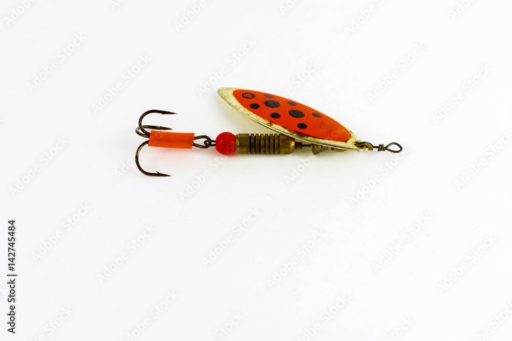 Exhibition of pirated copies of fishing metal spoon baits. Bait for fishing in the shape of a spoon with a hook on a white background Exhibition of pirated copies of fishing metal spoon baits. Bait for fishing in the shape of a spoon with a hook on a white background