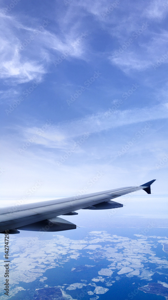 Fototapeta premium Aircraft wing over the earth’s atmosphere.