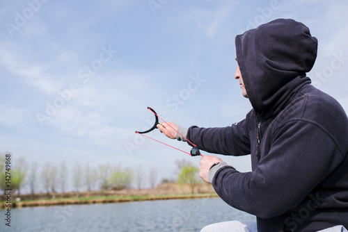 Valokuva Man feeding fish with slingshot
