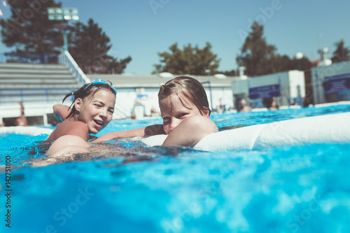 Underwater fun. Two cute little girls with goggles swimming underwater and diving in the swimming poll. Kids sport and leisure. © Dusko