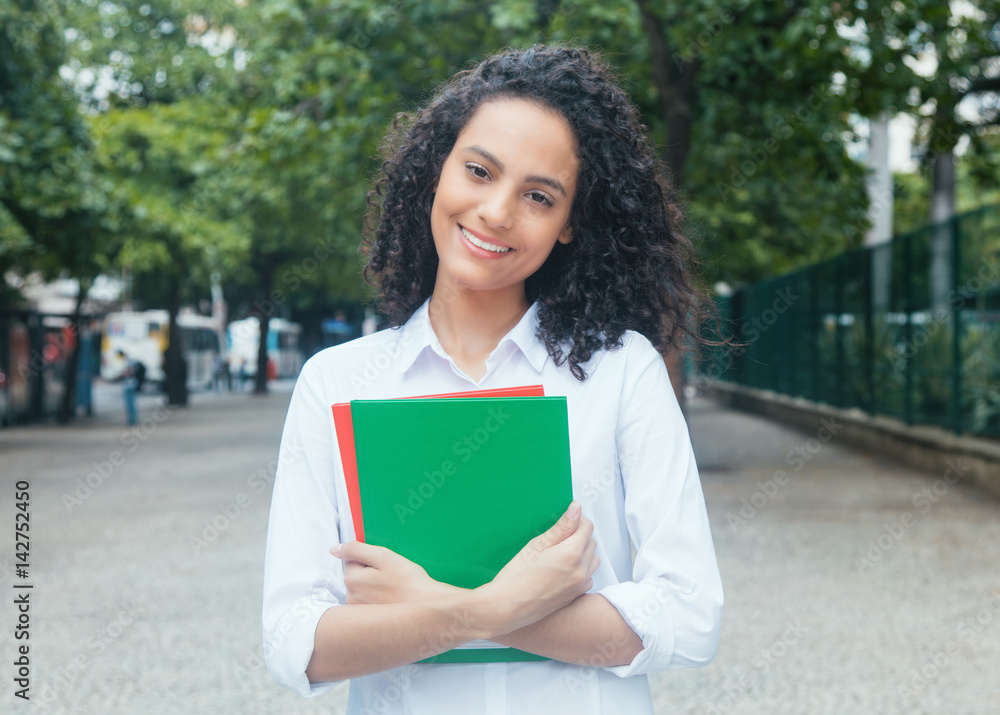 Beautiful latin female student with curly hair and white shirt Beautiful latin female student with curly hair and white shirt
