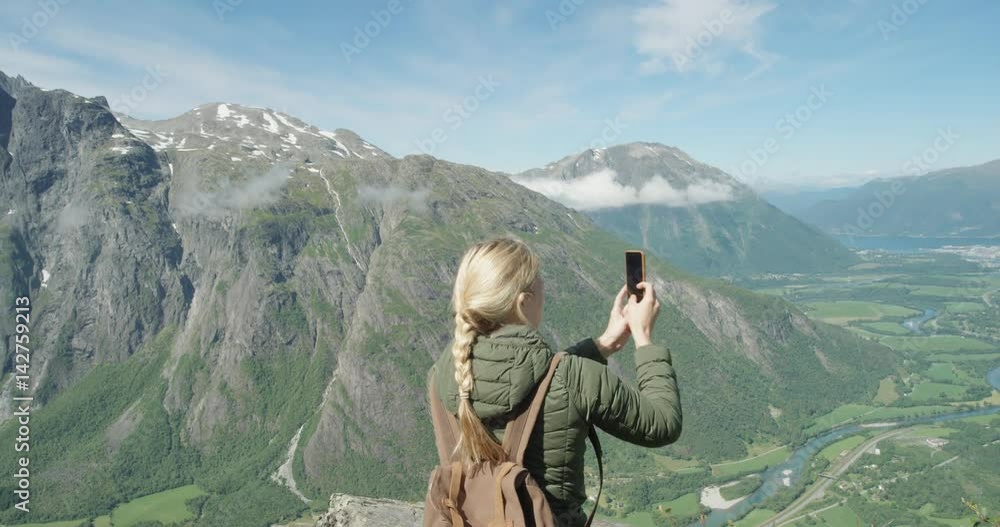 Woman taking panorama photo using smartphone Girl with braided hair photographing scenic landscape nature background view enjoying vacation travel adventure Romsdalen Valley Norway Woman taking panorama photo using smartphone Girl with braided hair photographing scenic landscape nature background view enjoying vacation travel adventure Romsdalen Valley Norway