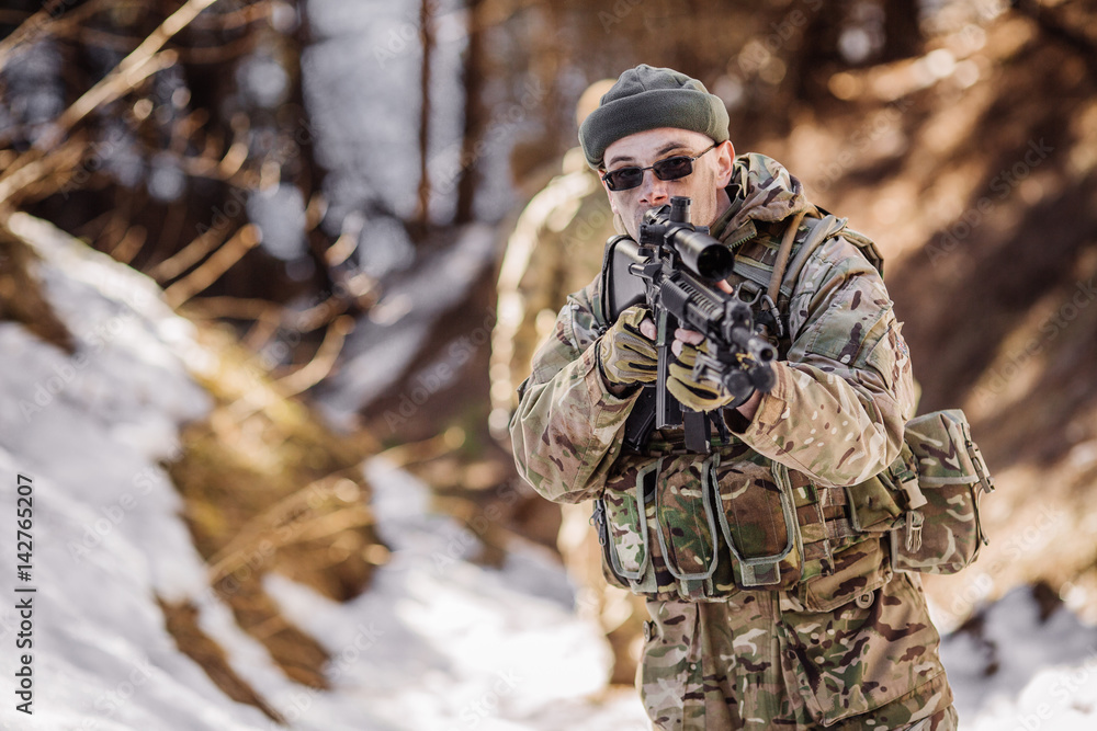 Fototapeta premium team of special forces weapons in cold forest. Winter warfare and military concept