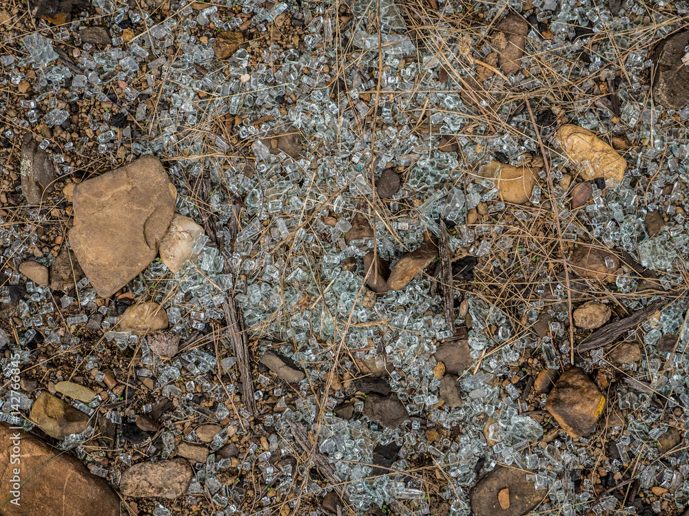 Obraz premium Smashed glass spread over the ground between rocks