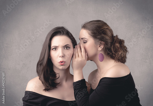 girl telling secret things to her girlfriend
