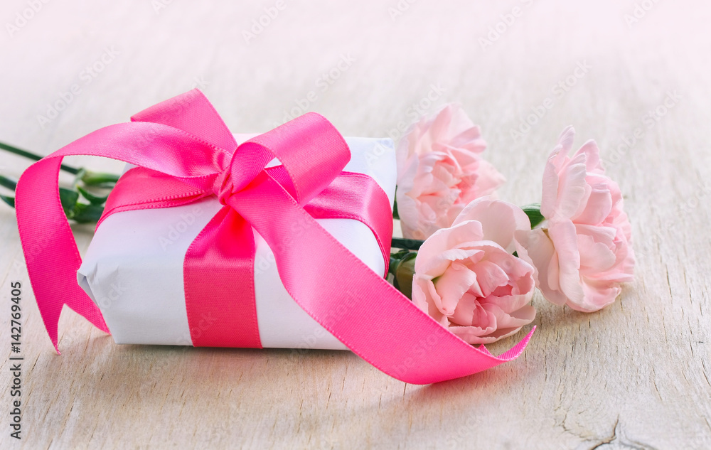 Mother's Day background, white gift box, three pink carnations