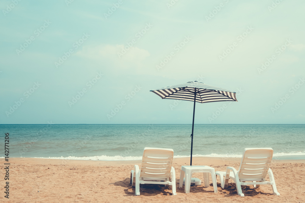 Couple beach chair on tropical beach. vintage color tone effect