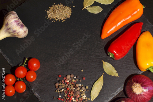Vegetables and spices before cooking dinner on a dark background, top view, copyspace