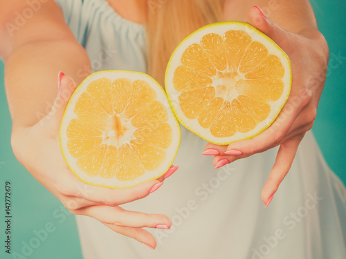 Halfs of yellow grapefruit citrus fruit in human hands