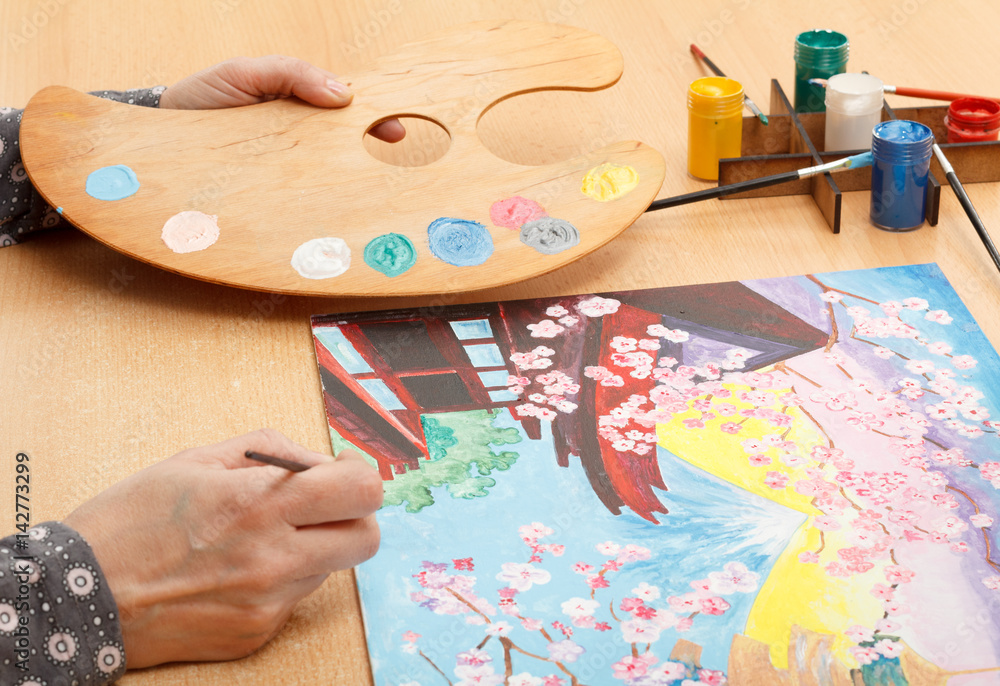 Woman's hand painting Japanese landscape