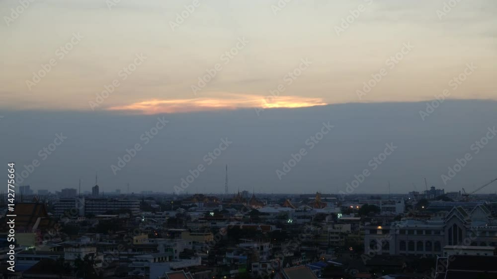 A time lapse of the large orange sunset as the massive sun sets into the horizon above the city A time lapse of the large orange sunset as the massive sun sets into the horizon above the city