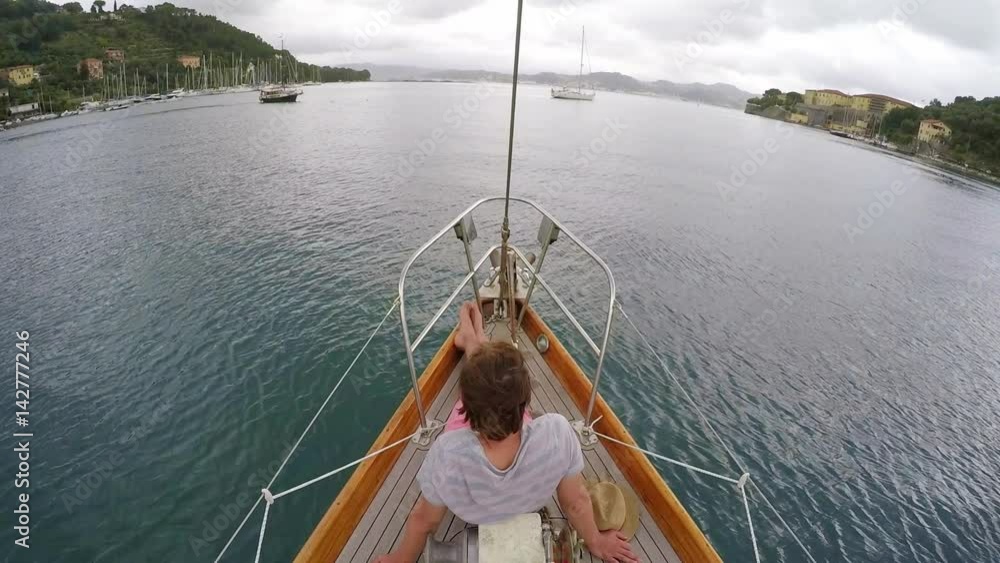 happy man relaxing on deck of wooden sailboat in ocean on travel adventure vacation happy man relaxing on deck of wooden sailboat in ocean on travel adventure vacation