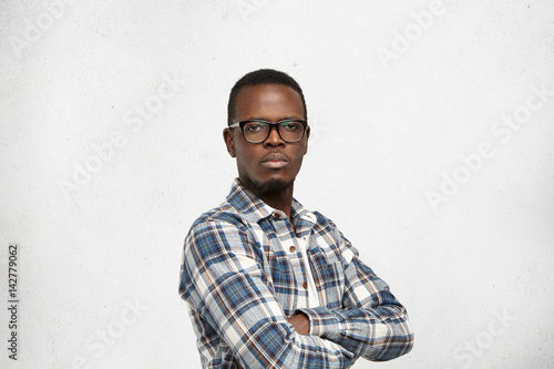 Foto Arrogant Afro-American young hipster wearing glasses in black frame and checkere
