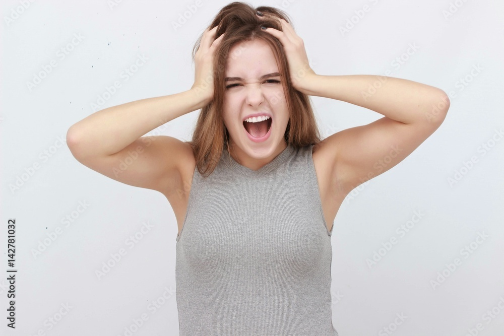 Young woman has headache, isolated on gray background