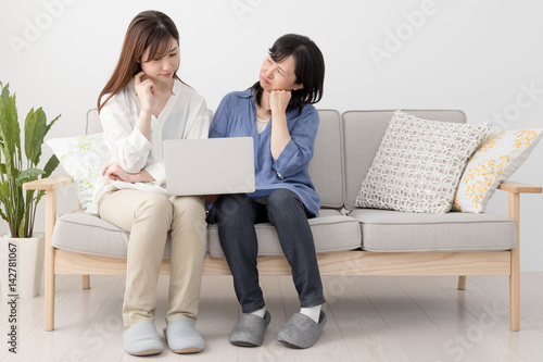 ノートパソコンを使う親子、母、娘、悩む