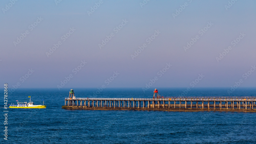 Ship entering Whitby Pier, North Yorkshire, UK