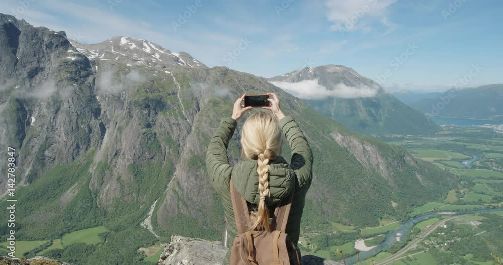 Woman taking panorama photo using smartphone Girl with braided hair photographing scenic landscape nature background view enjoying vacation travel adventure Romsdalen Valley Norway Woman taking panorama photo using smartphone Girl with braided hair photographing scenic landscape nature background view enjoying vacation travel adventure Romsdalen Valley Norway