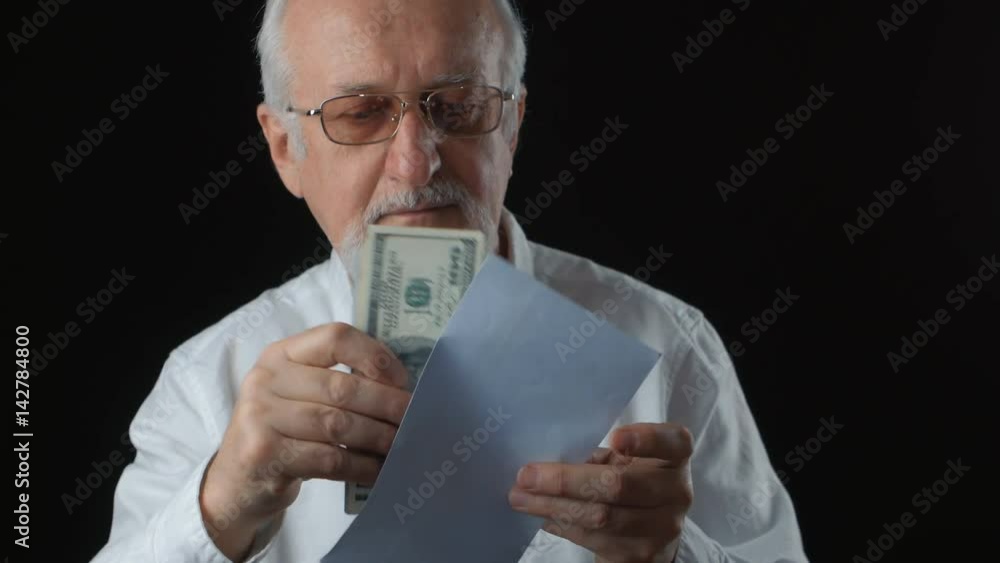 Senior man gets envelope with money. He counts dollar bills. Salary concept Senior man gets envelope with money. He counts dollar bills. Salary concept