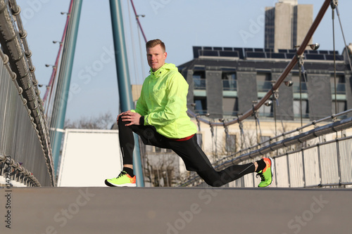 Läufer beim Stretching auf einer Brücke © grafikwerk21
