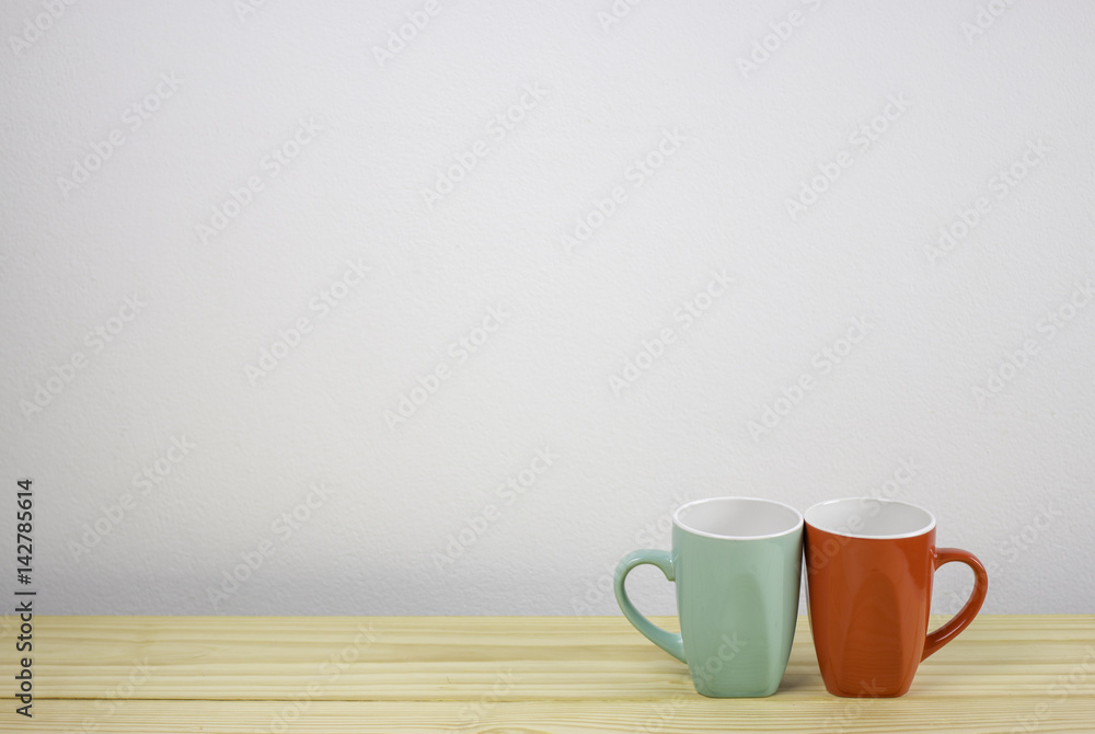 green and red coffee mug on wooden table. focus on mug green and red coffee mug on wooden table. focus on mug