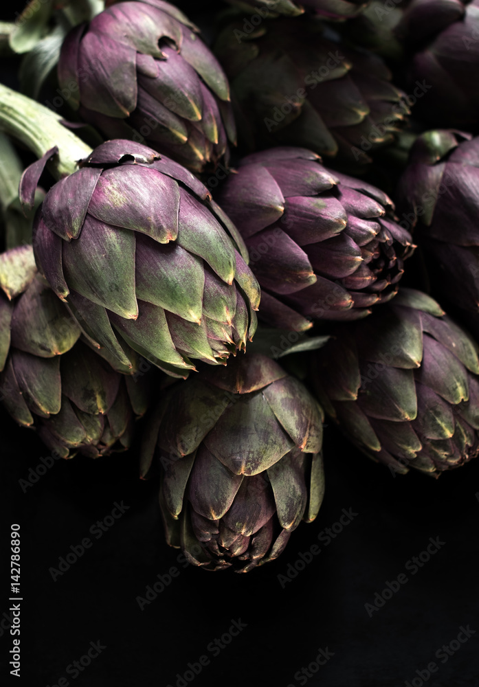 Fototapeta premium Ingredients. Fresh textured artichokes on a dark backgroun