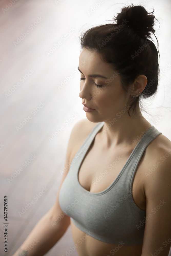 Portrait of Young attractive yogi woman practicing yoga concept, sitting and meditating, relaxing with her eyes closed, working out, wearing sportswear, studio or home background. Meditation session Portrait of Young attractive yogi woman practicing yoga concept, sitting and meditating, relaxing with her eyes closed, working out, wearing sportswear, studio or home background. Meditation session