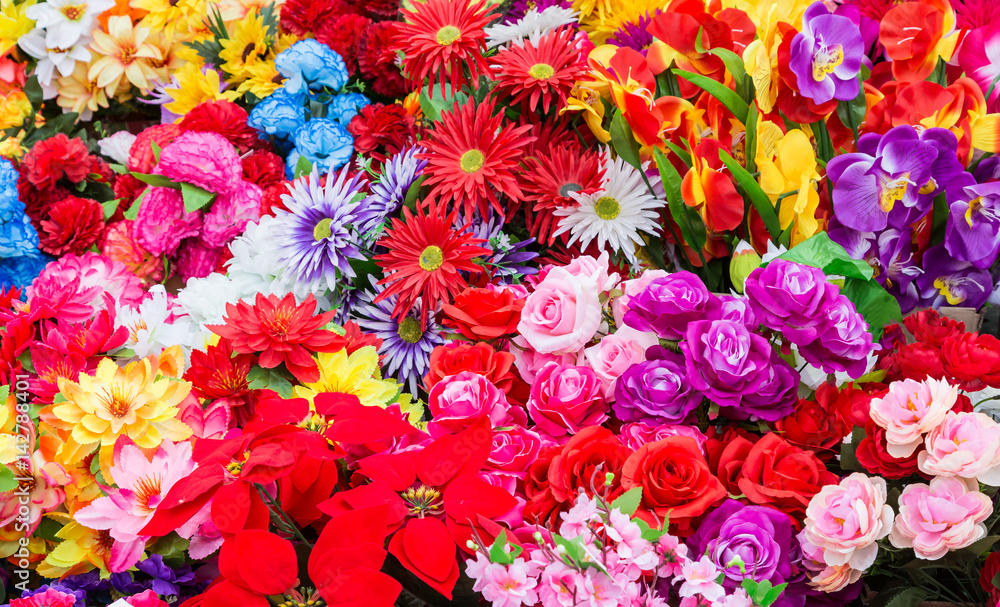 A variety of artificial flowers. Colorful background of flowers A variety of artificial flowers. Colorful background of flowers
