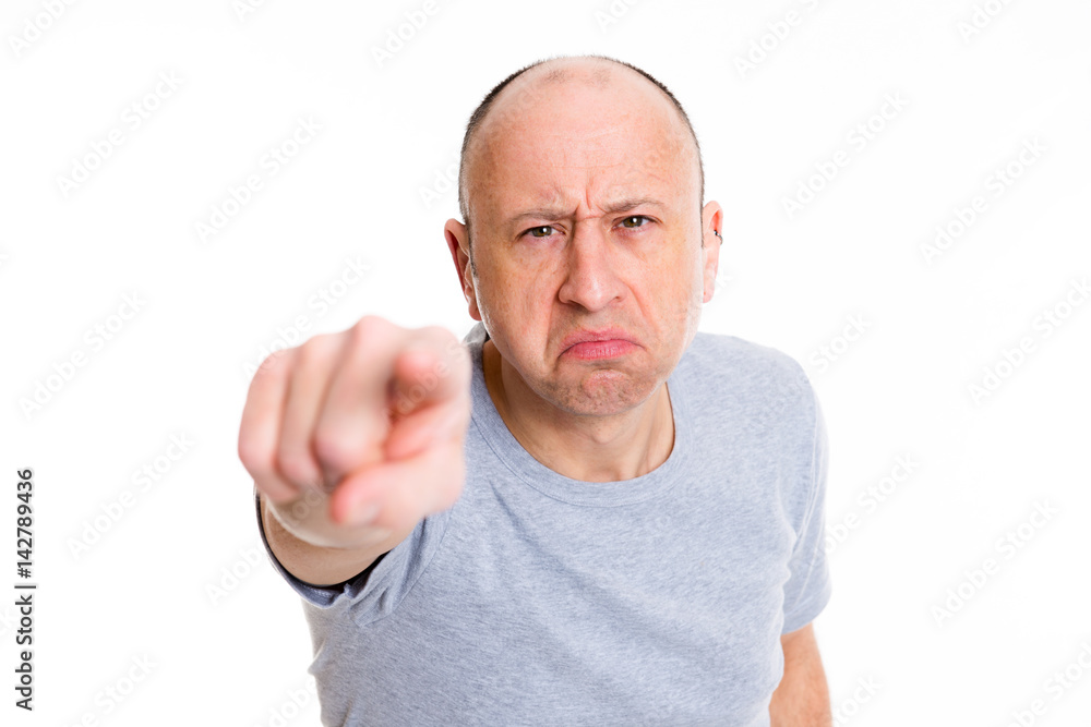 angry baldheaded man pointing in to the camera and smiling angry baldheaded man pointing in to the camera and smiling