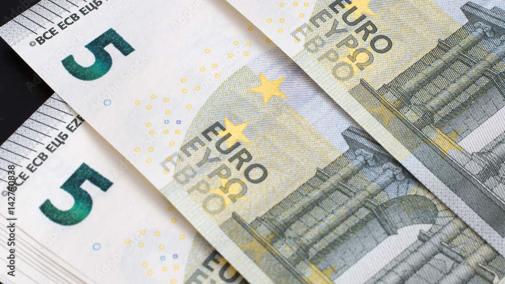  Euro banknotes and coins lie on top of each other