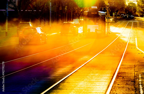 A famous Melbourne tram on its tracks on a bright summer afternoon with colorful lens flare.