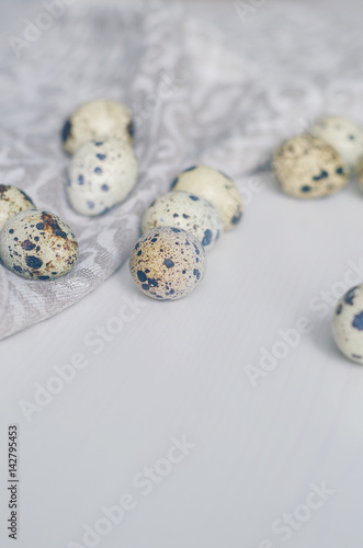 Scattered quail eggs on a linen napkin. Prepare to Easter. Toned in cold scale