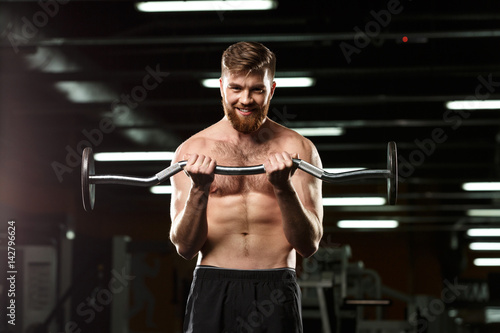 Happy sports man make sport exercises with barbell