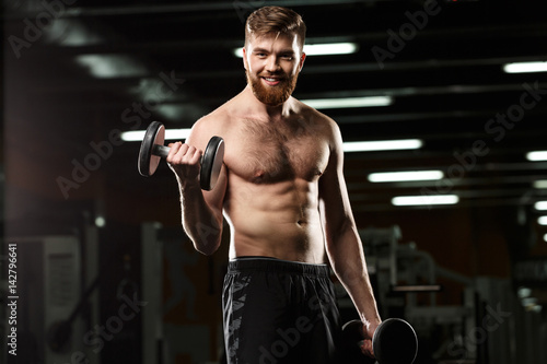 Happy sports man make sport exercises with dumbbells