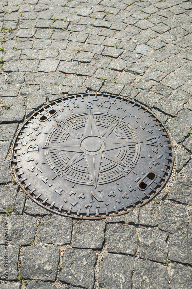 manhole with wind rose on the stone pavement