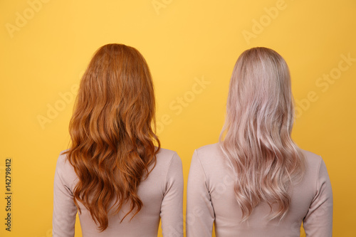 Back view photo of young redhead and blonde ladies